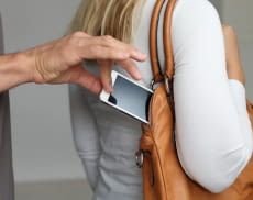 Hand zieht Handy aus Handtasche